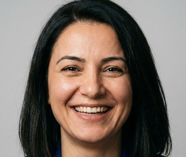 Mavi ceketli, gülümseyen kadın portresi